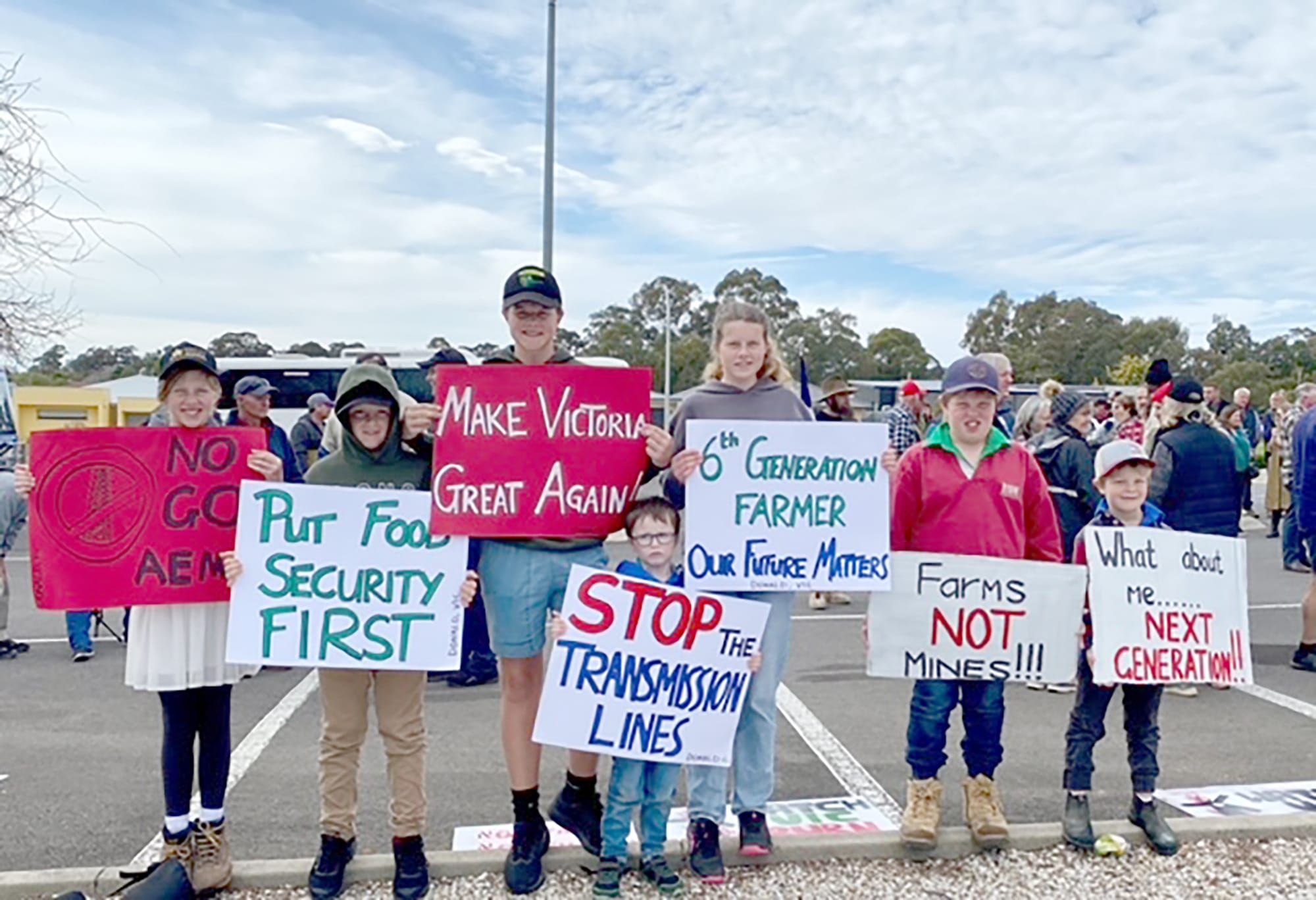 Ellie Burke, Darcy Burke, Marty Burke, Percy Burke, Sophie Burke, James Tischler and Charlie Tischler with their signs. (Photo by Susie Burke).