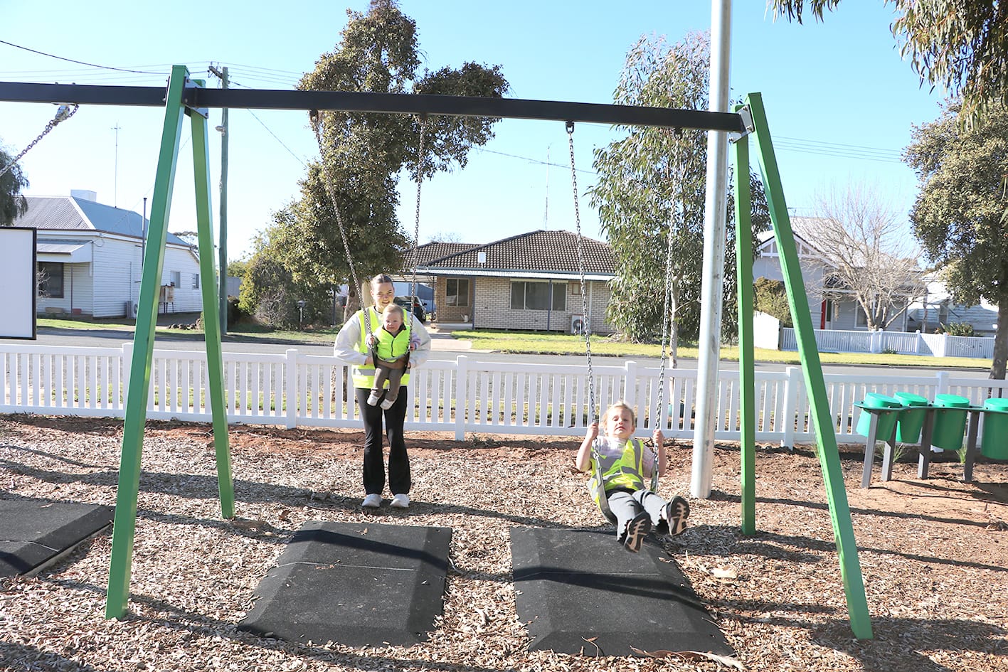 Hannah Cook helps Lucy Rickard and Violet Lehmann on the swings.