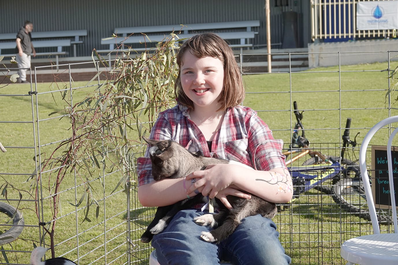 Madelaine Morton loving cuddles with a baby goat.