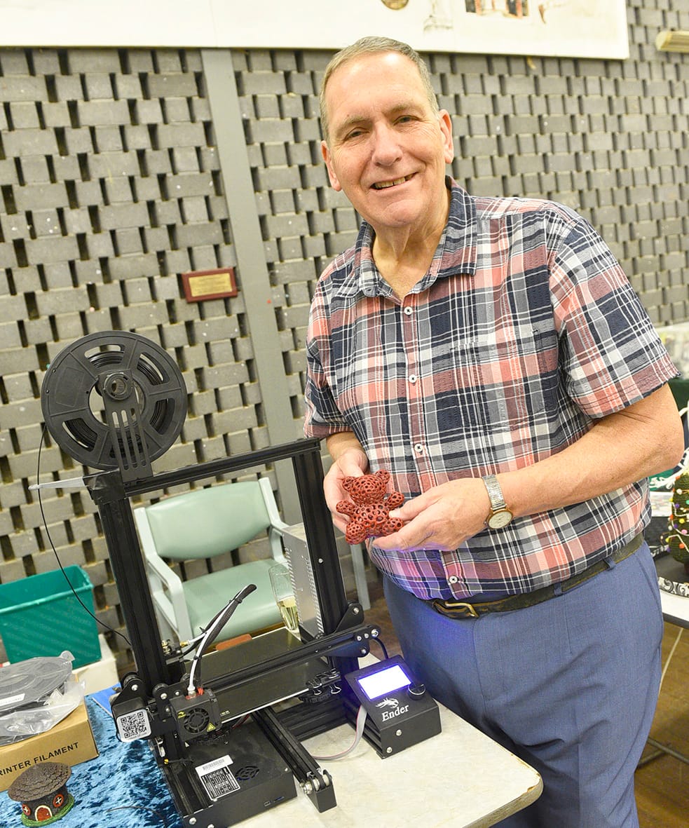 Demonstrator, Markus Phillips is pictured with his 3D printing machine and some of the manufactured items.